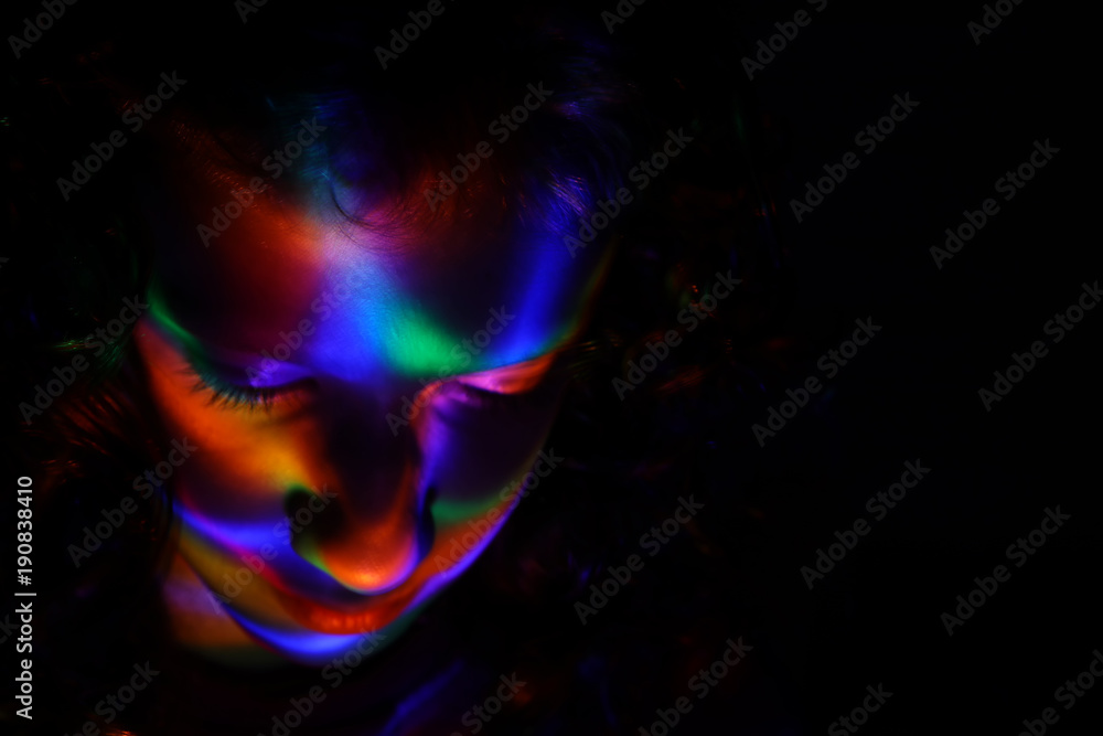 Fototapeta premium abstract portrait of young girl under colorful fluorescent Neon dark lights, enigmatic style.