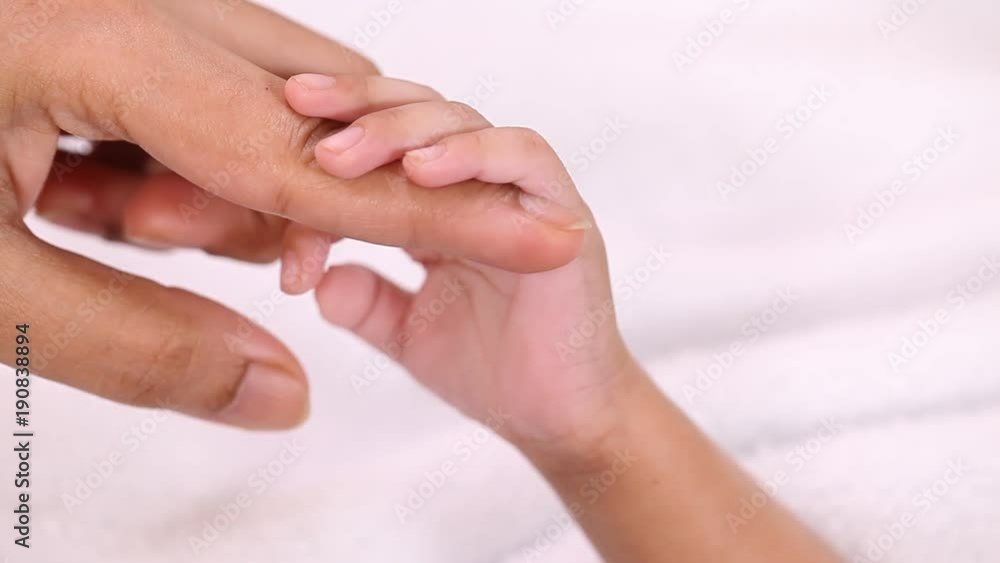 Newborn baby boy gripping mother's finger Newborn baby boy gripping mother's finger