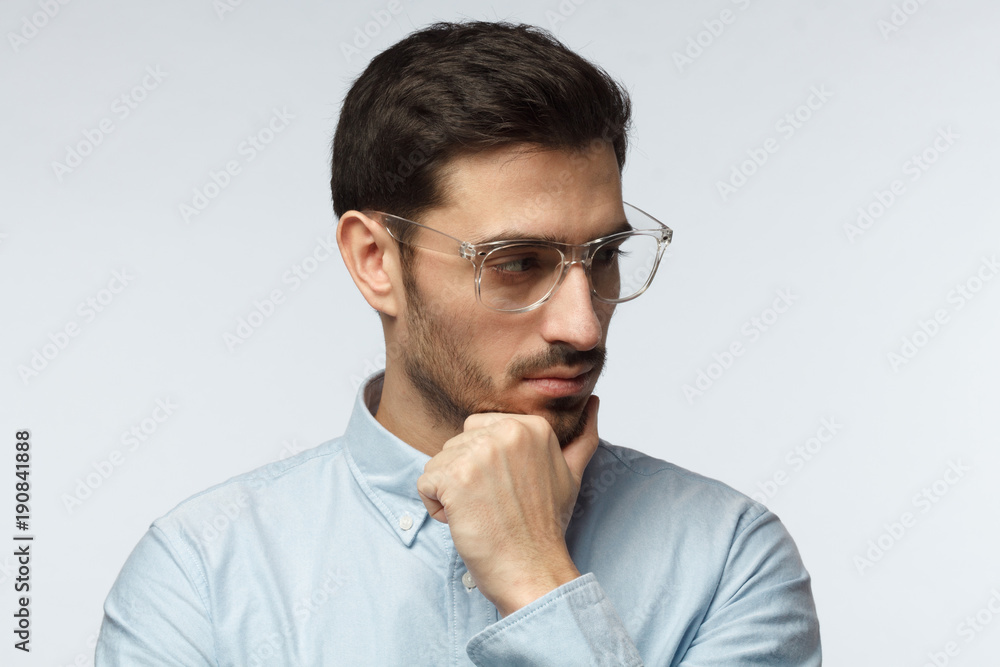 Close up portrait of suspicious doubtful business man isolated on grey background Close up portrait of suspicious doubtful business man isolated on grey background