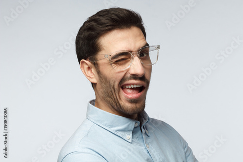 Handsome man smiling and winking, looking at camera