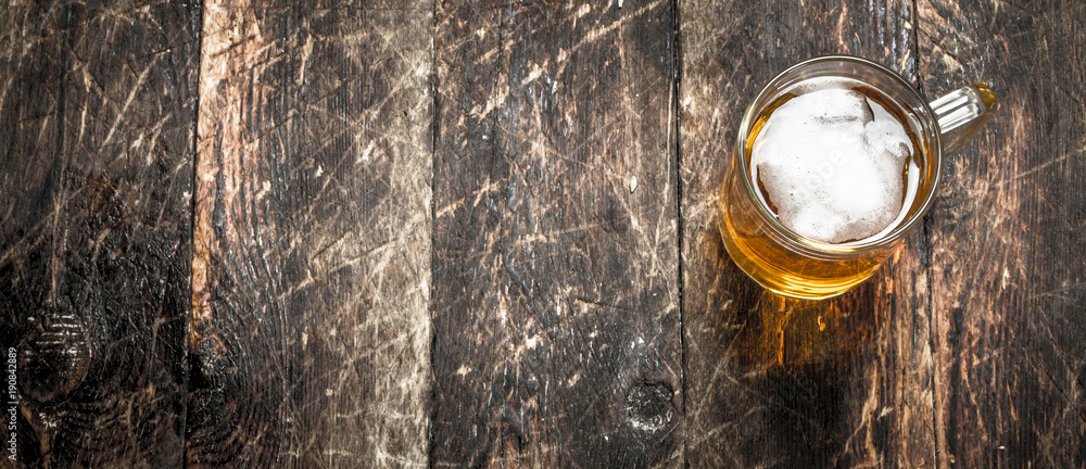 glass of fresh beer. On wooden background. glass of fresh beer. On wooden background.