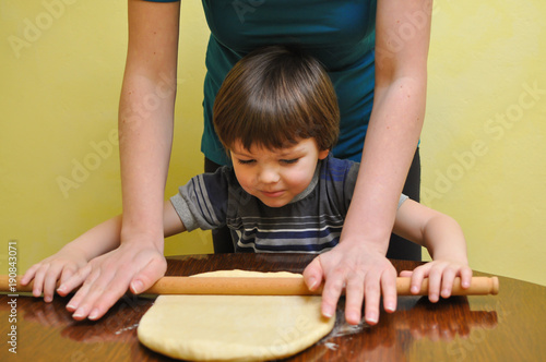 Mom and son prepare dough for a homemade strudel. Making domestic cookies.