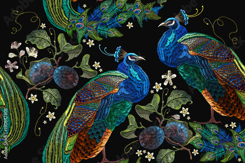 Embroidery peacocks tropical birds and plum branch seamless pattern. Classical fashionable embroidery beautiful peacocks. Fashionable template for design of clothes