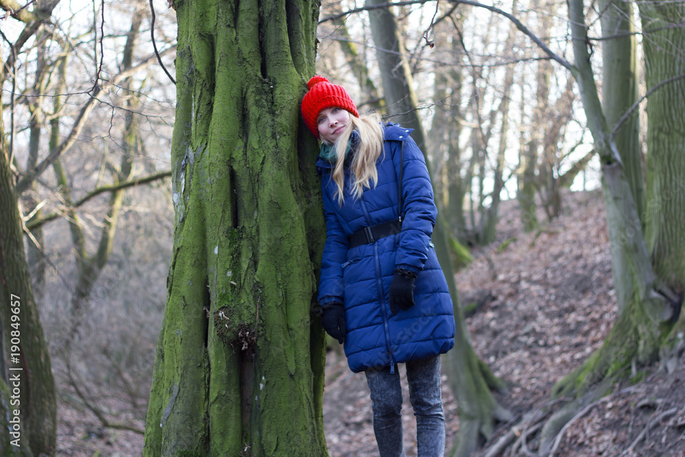 woman leaning against tree in forest