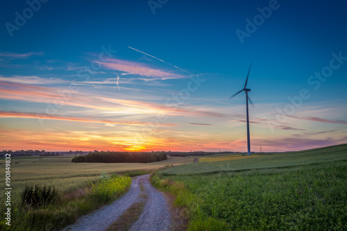Stunning dusk over field wind turbines in summer, Europe