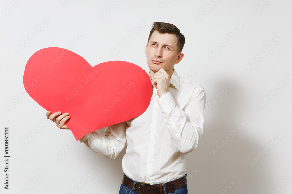 Young handsome man in shirt holding big red heart isolated on white background. Copy space, advertisement. Place for text. St. Valentine's Day, International Women's Day, birthday, holiday concept. Young handsome man in shirt holding big red heart isolated on white background. Copy space, advertisement. Place for text. St. Valentine's Day, International Women's Day, birthday, holiday concept.