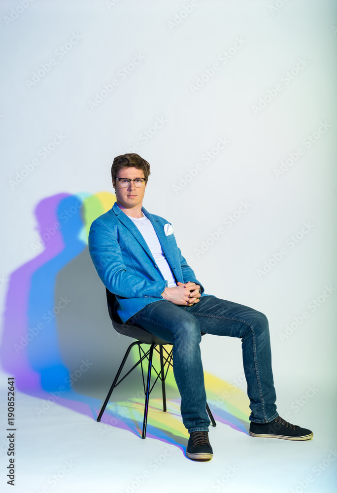 Full length portrait of serene man sitting on chair. Composure concept Full length portrait of serene man sitting on chair. Composure concept