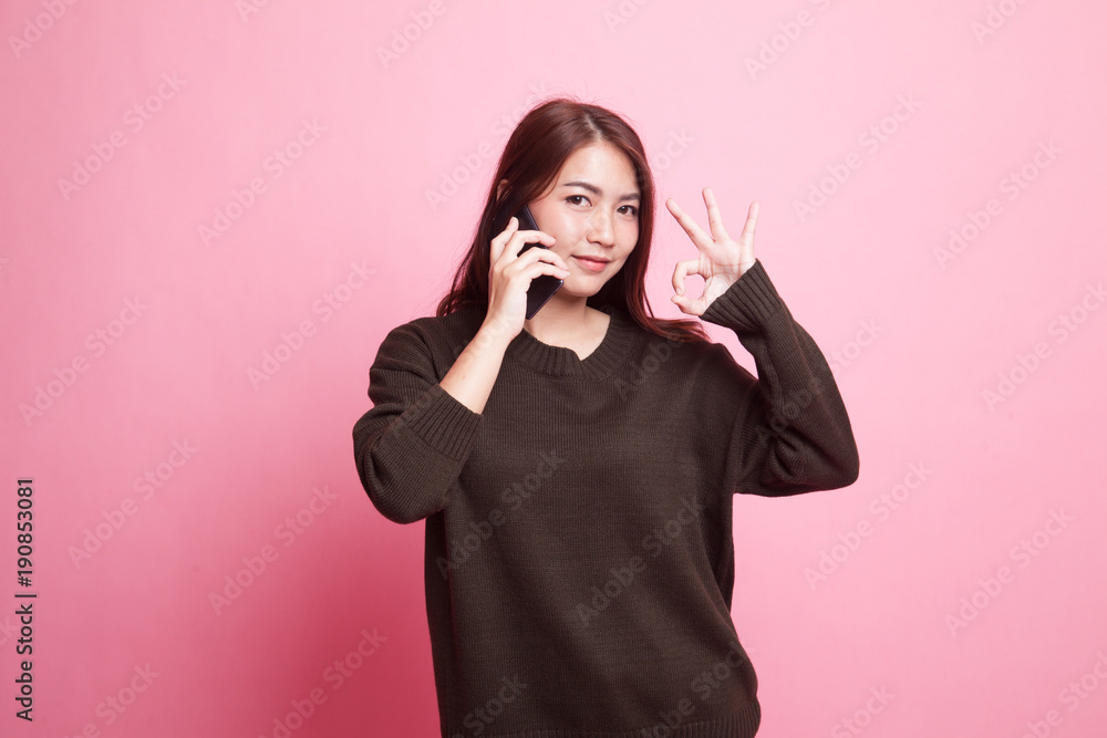 Young Asian woman show with phone gesture and OK sign. Young Asian woman show with phone gesture and OK sign.