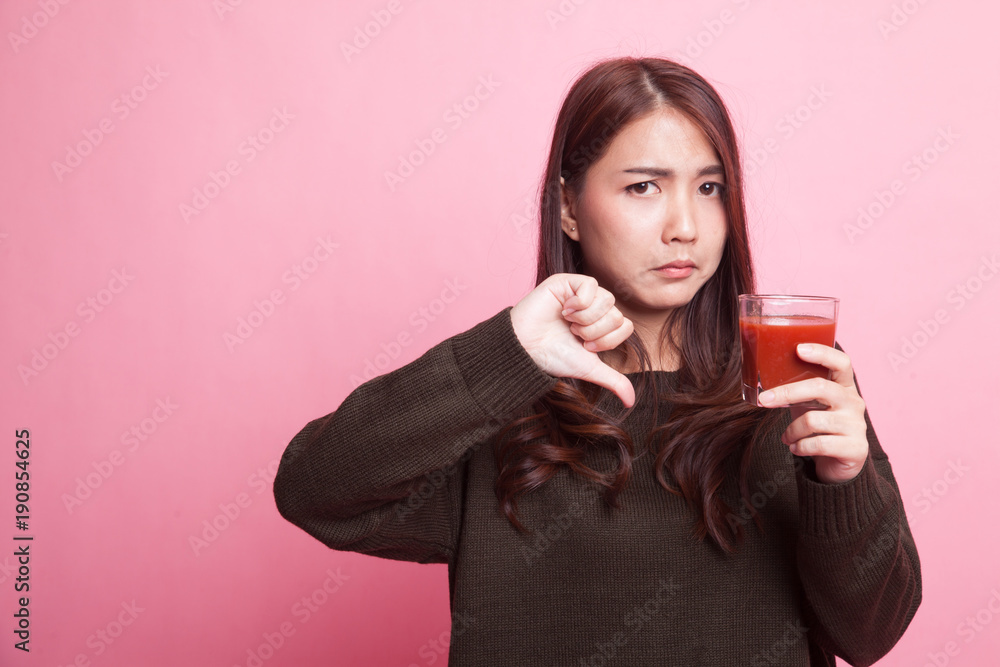 Asian woman thumbs down hate tomato juice. Asian woman thumbs down hate tomato juice.
