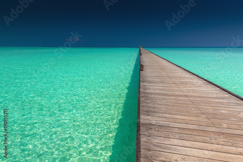 Wooden long jetty over lagoon with amazing clean azure water © Martin Valigursky