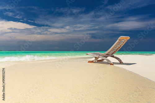 Tropical beach view of amazing water and empty chair on sand for relaxed vacations