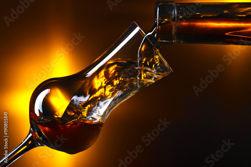 Canvas Print Pouring alcohol drink into a wineglass .