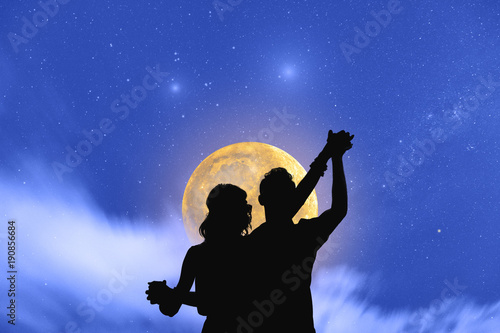 Obraz na plátně Young couple dancing under the moonlight and stars.