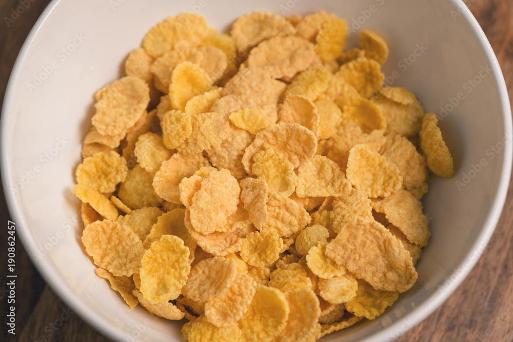 corn flakes in white bowl closeup corn flakes in white bowl closeup