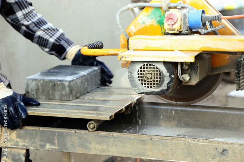 Fototapeta premium Worker on the circular tile saw