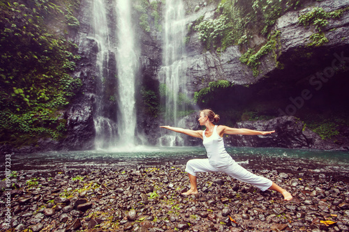 Woman practices yoga near Sekumpul waterfall in Bali  Indonesia