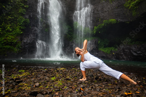 Woman practices yoga near Sekumpul waterfall in Bali  Indonesia