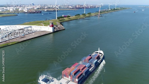Aerial of container ship moving through Maeslantkering storm surge barrier showing heavy ship exhaust plume on Nieuwe Waterweg Netherlands barrier closes if city of Rotterdam is threatened by floods photo