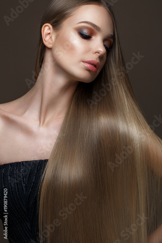 Beautiful blond girl with a perfectly smooth hair  classic make-up and red lips. Beauty face. Picture taken in the studio on a white background.