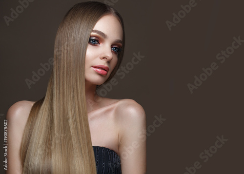 Beautiful blond girl with a perfectly smooth hair, classic make-up and red lips. Beauty face. Picture taken in the studio on a white background.
