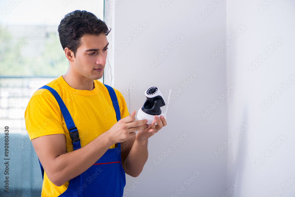 Contractor installing surveillance CCTV cameras in office Contractor installing surveillance CCTV cameras in office