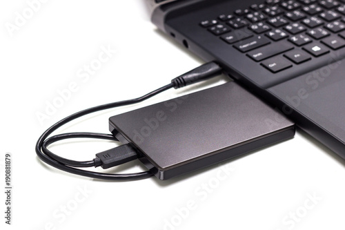black external hard drive connect to laptop computer isolated white background 