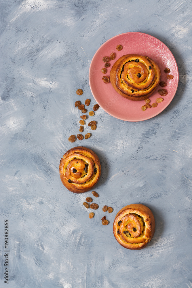 Buns with raisins on a gray background. Top view, copy space. Buns with raisins on a gray background. Top view, copy space.