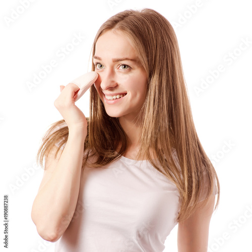 Beautiful young woman in the hands of a cosmetic sponge