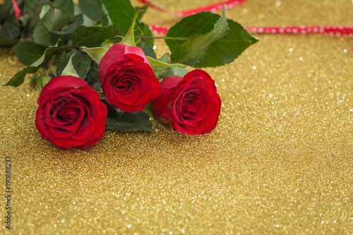 beautiful red roses on the shiny gold background with place for dedications or wishes