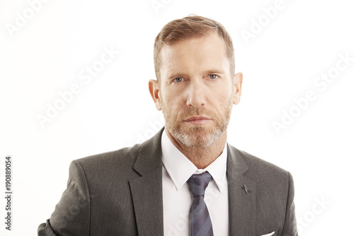 Executive businessman portrait. Successful smiling lawyer wearing suit and looking at camera while standing at isolated white background with copy space. 