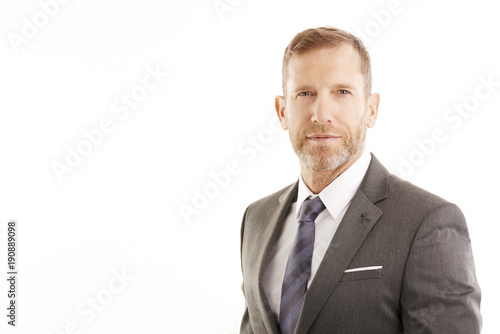 Executive businessman portrait. Successful smiling lawyer wearing suit and looking at camera while standing at isolated white background with copy space. 