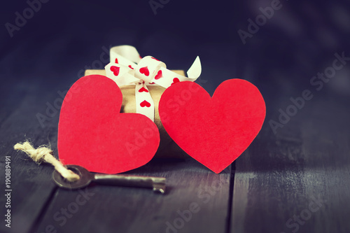 Red paper heart old key and presents on a dark wooden background. St. Valentine's Day. Copy space. photo