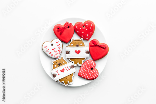 Sweet gift on Valentine's Day. Heart shaped cookies and bear with lettering I love you on white background top view copy space