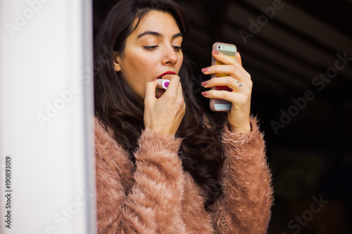 Girl putting red lipstick
