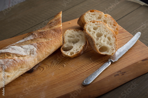 A baguette on a wooden background.