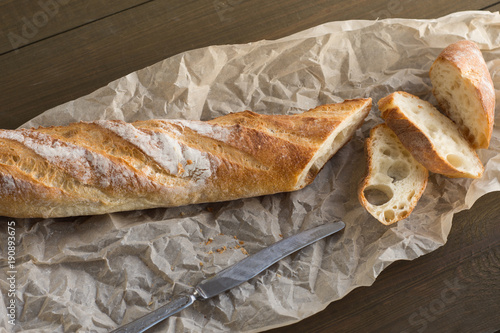 A baguette on a wooden background.
