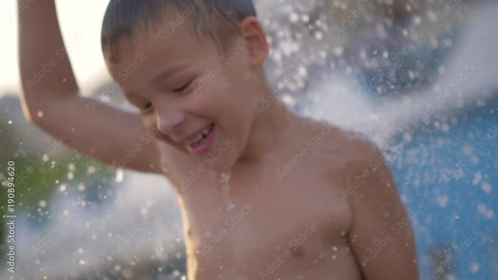 Slow motion shot of a happy kid dancing when taking outdoor beach shower after bathing in sea Slow motion shot of a happy kid dancing when taking outdoor beach shower after bathing in sea