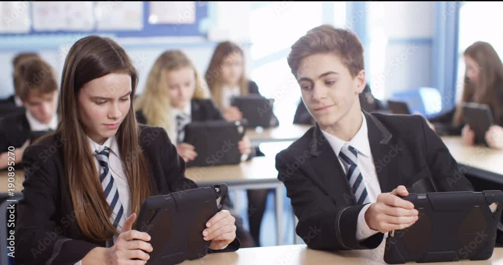 4k, Secondary school students using digital touchscreen tablet in a classroom. 4k, Secondary school students using digital touchscreen tablet in a classroom.