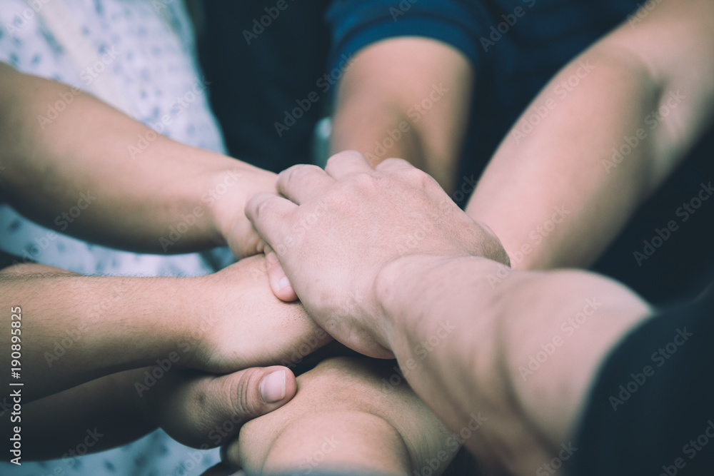Teamwork concept; many people standing hands together in field before starting competition game Teamwork concept; many people standing hands together in field before starting competition game