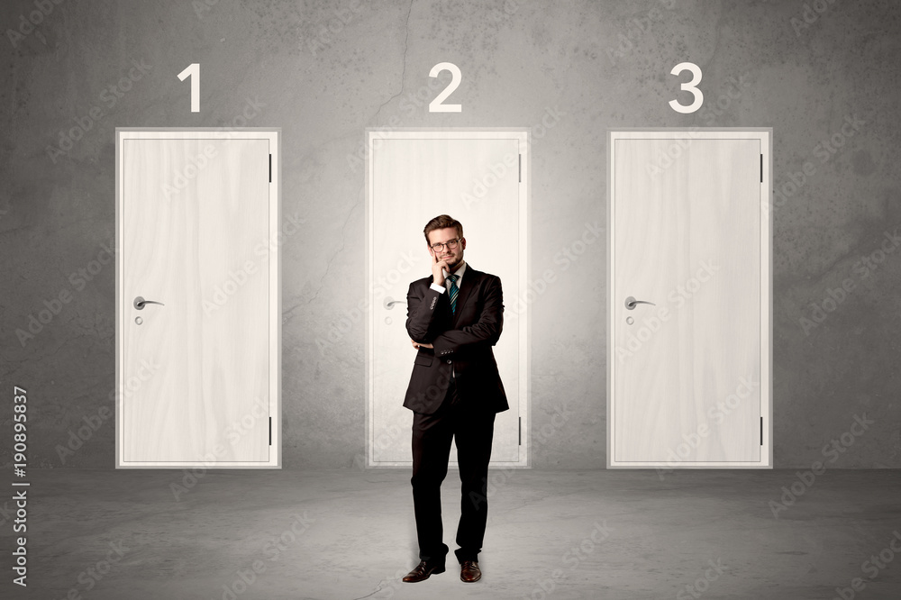 Fototapeta premium Businessman thinking in front of three doors