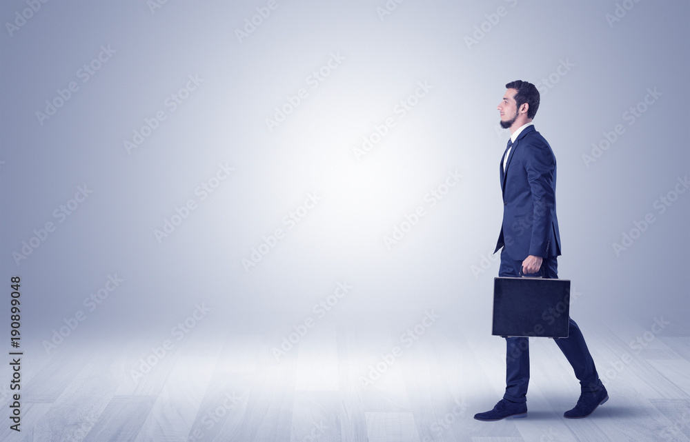 Businessman walking in front of an empty wall Businessman walking in front of an empty wall
