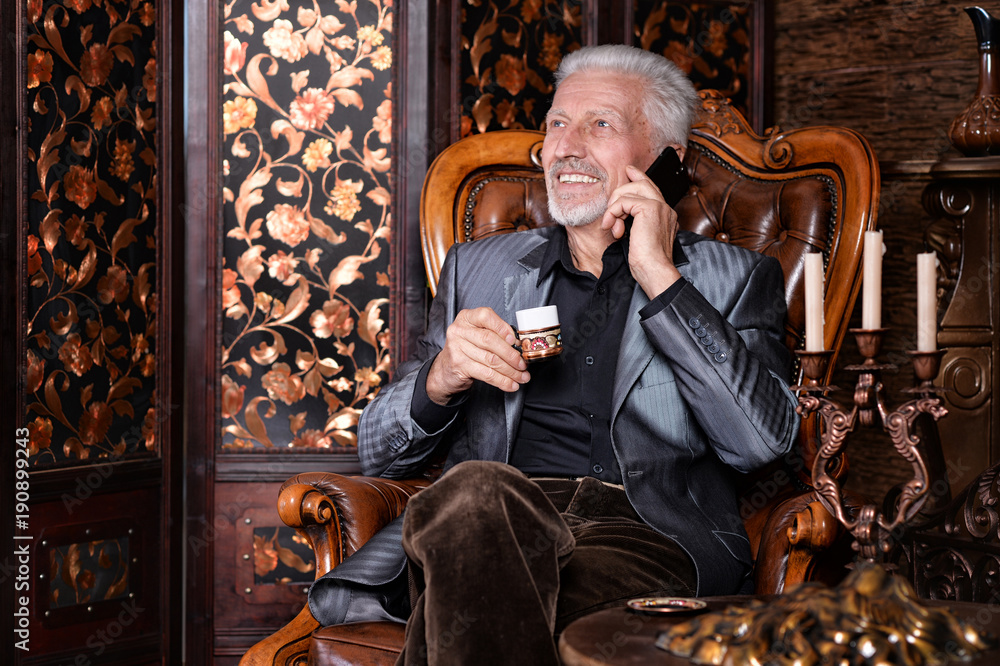 senior man drinking coffee and talking on phone senior man drinking coffee and talking on phone