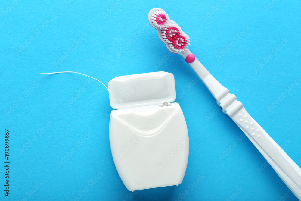 Obraz premium Toothbrush with tooth thread on blue background