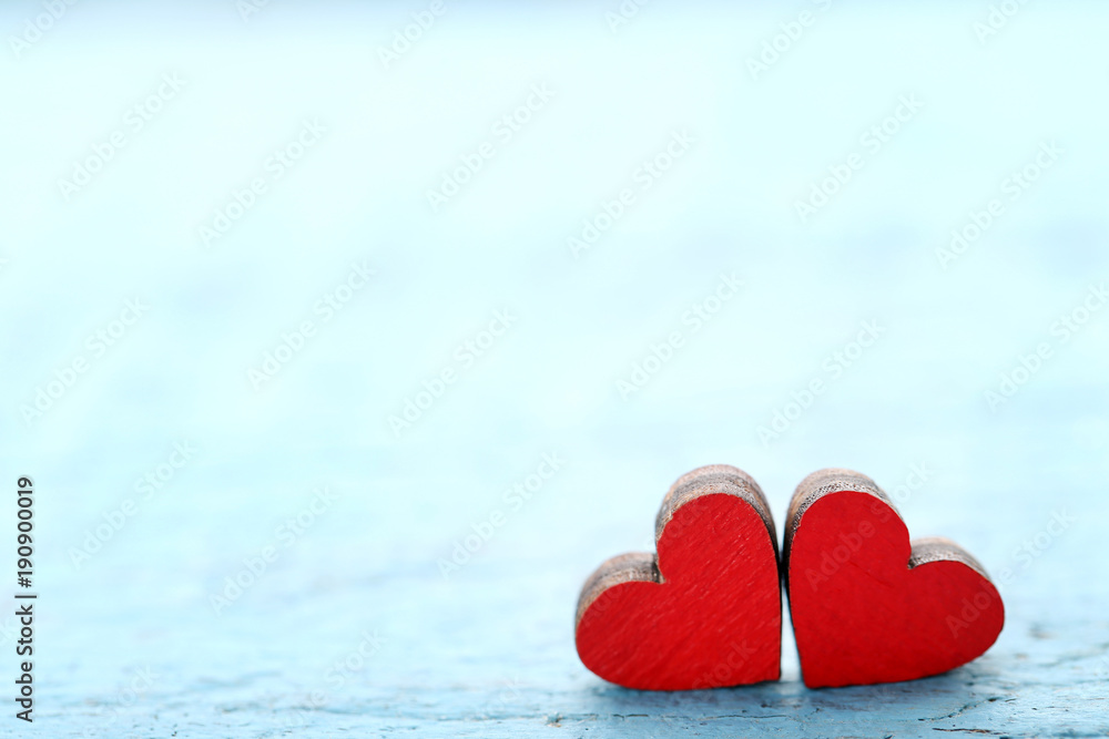 Fototapeta premium Red wooden hearts on blue table