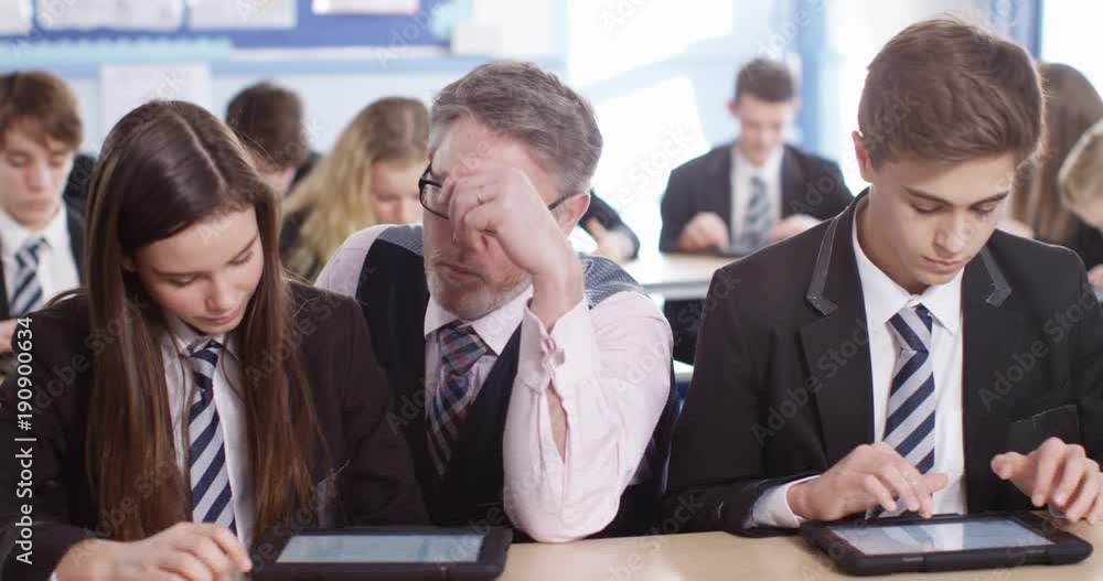 4k, Teacher and school children using a digital tablet while sitting in class 4k, Teacher and school children using a digital tablet while sitting in class