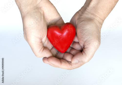 Hands holding a red heart shaped Valentine figurine