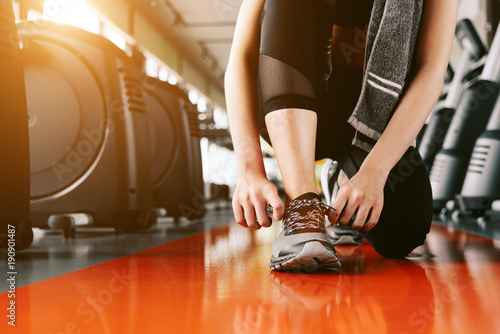 Sport woman tying sneakers rope. Sport center and Fitness gym concept. Healthy and Body build up theme. Sport wear and Fashion theme
