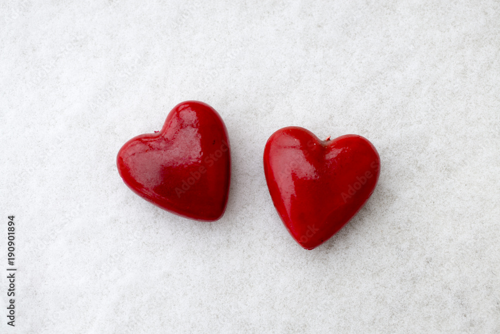 Two red heart shaped figurines on the snow