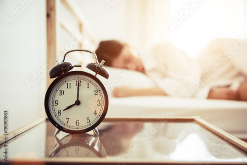 Alarm clock with beauty woman in background. Morning and Lazy time concept. Bedroom theme.