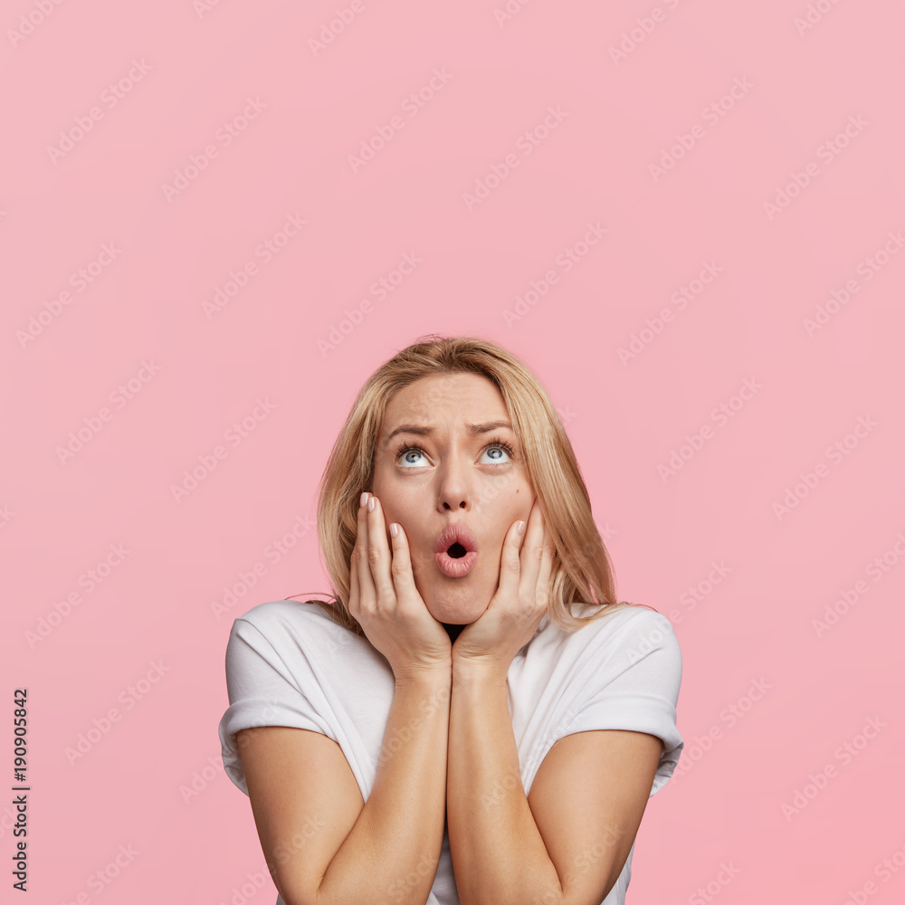 Φωτογραφία Stunned pleasant looking woman with blue eyes and blonde hair looks with horrifi